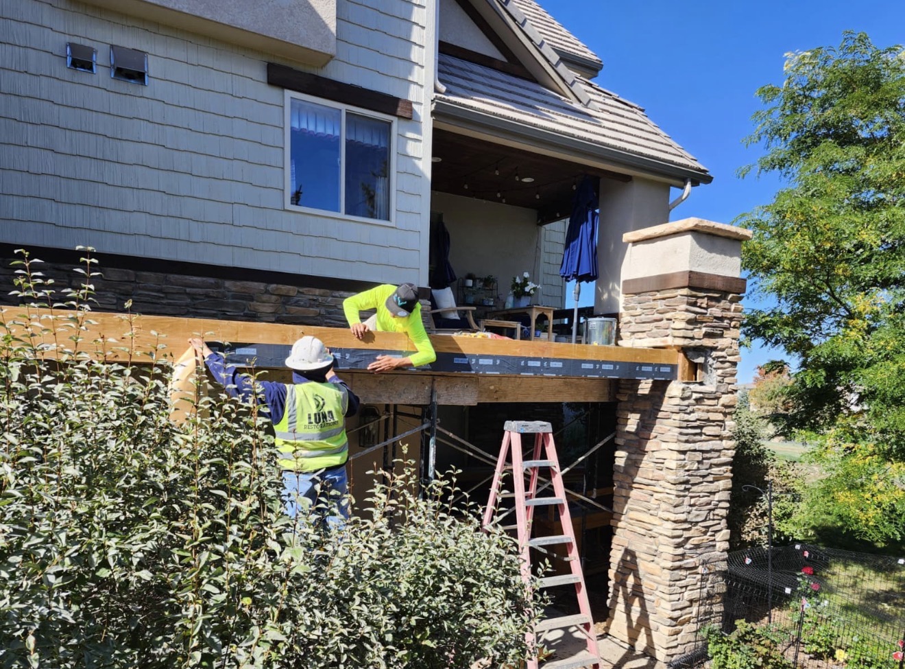 Luna Restorations crew installing waterproofing on the deck ledger
